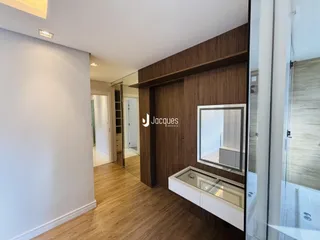 Corredor interno com piso de madeira clara e paredes brancas em um imóvel no Brasil.