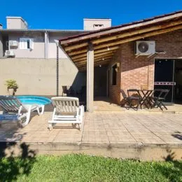 Área externa com piso de ladrilhos e estrutura de madeira em um imóvel em Lajeado.