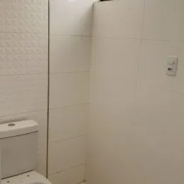 Parede interna com revestimento branco em um ambiente de imóvel.