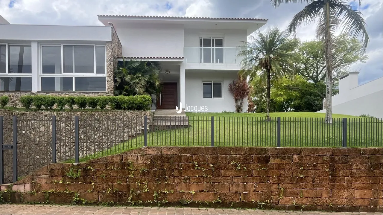 Fachada de uma residência em Lajeado, Brasil, com jardim frontal e cerca.