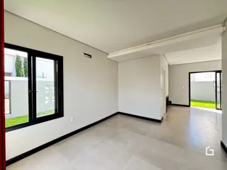 Vista interna de uma sala com piso claro e paredes brancas.