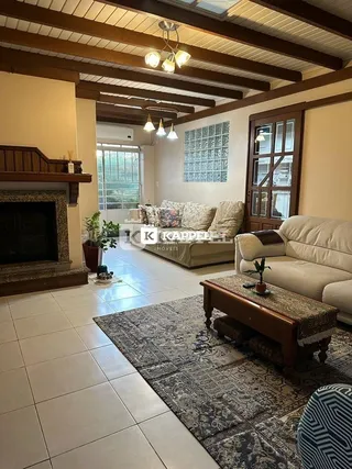 Sala de estar com sofá e lareira em ambiente com vigas de madeira.