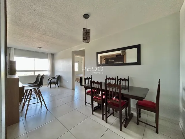 Sala de jantar com mesa de madeira e janela em um imóvel no Brasil.