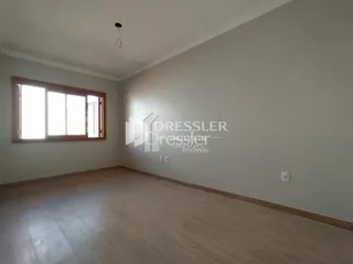 Imagem de uma sala com piso de madeira e janela.