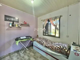 Quarto com paredes roxas e janela com cortinas.