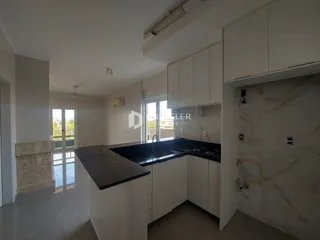 Foto de uma cozinha moderna com armários brancos e bancada escura.