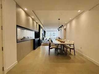 Interior de uma sala de estar e jantar moderna com armários embutidos.