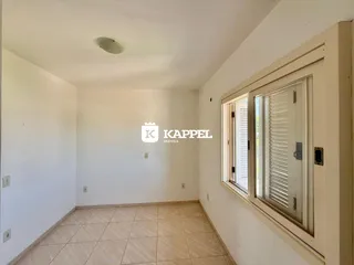 Foto de um cômodo interno com paredes brancas e piso de cerâmica.
