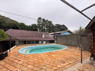 Foto da área externa com piscina e piso de tijolos.