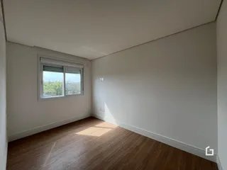 Ambiente interno de uma sala com piso de madeira clara.