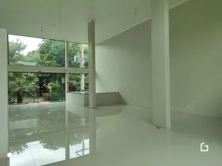 Ambiente interno de uma sala ampla com grandes janelas de vidro.