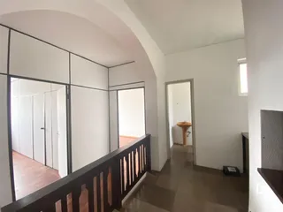 Hall de entrada com piso de madeira e grade escura.