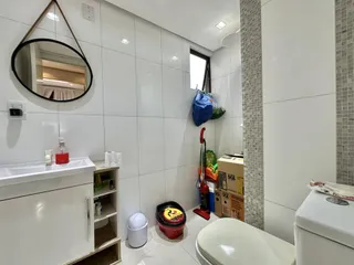 Um banheiro moderno com revestimento branco.