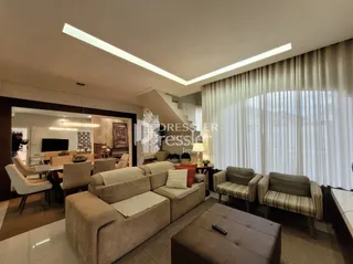 Sala de estar com cortinas claras e sofá.