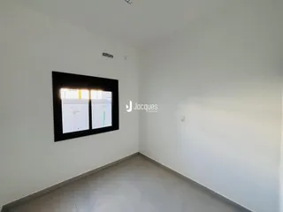 Vista interna de um cômodo com paredes brancas e piso claro.