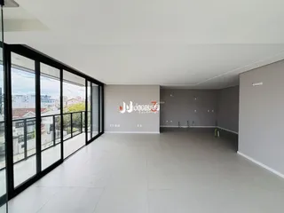 Interior de uma sala ampla com grandes portas de vidro.