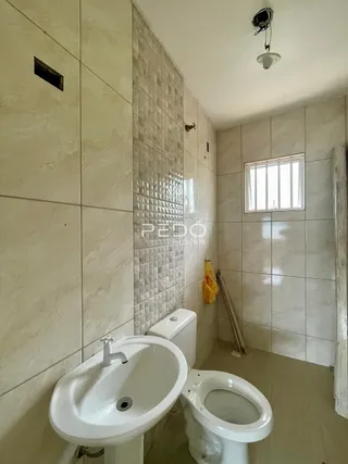 Foto de um banheiro com revestimento de azulejos claros.