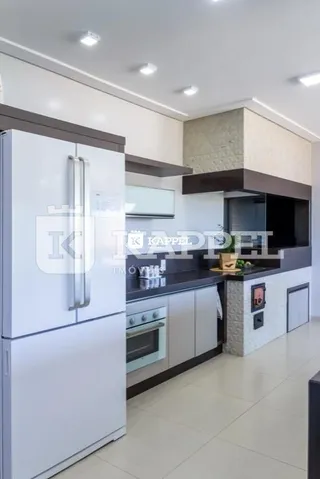 Foto de uma cozinha com armários brancos e bancadas escuras.