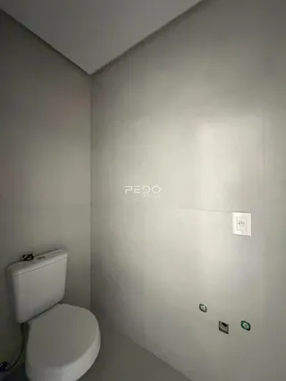 A foto mostra uma parte interna de um ambiente com um vaso sanitário.