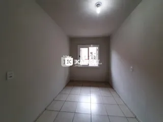 Vista de um corredor interno com piso de cerâmica claro e paredes brancas.