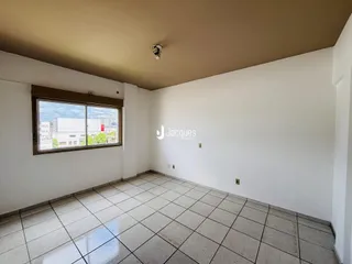 Ambiente interno de uma sala com piso de cerâmica e janela.