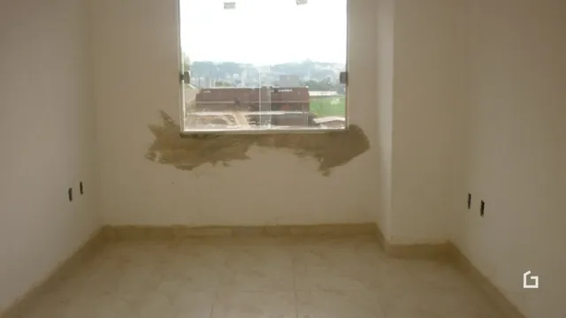 Interior de uma sala com paredes em estado de acabamento.