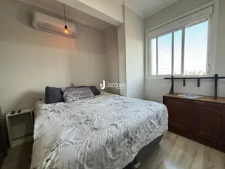 Quarto com cama e janela em um apartamento.