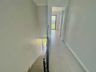 Hall de entrada com escadaria e porta em um imóvel.
