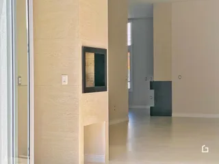 Hall de entrada de uma residência com paredes claras e piso claro.