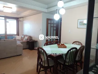 Sala de estar com sofá e mesa de jantar de madeira em um imóvel.