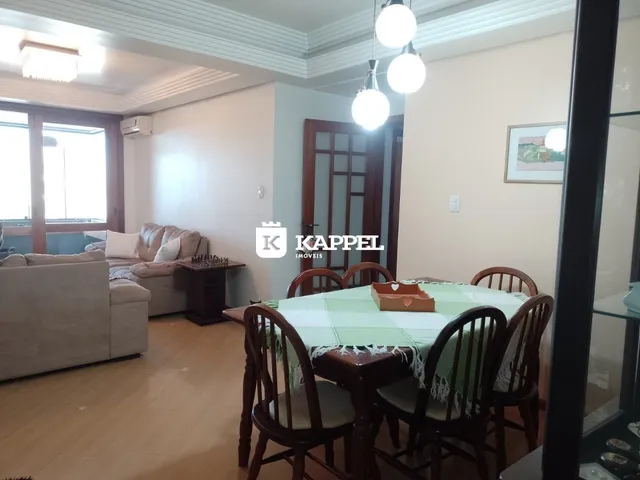 Sala de estar com sofá e mesa de jantar de madeira em um imóvel.