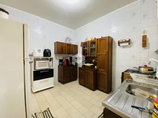 Foto de uma cozinha com armários de madeira e piso de cerâmica clara.