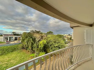 Vista da varanda mostrando vegetação e paisagem da região.