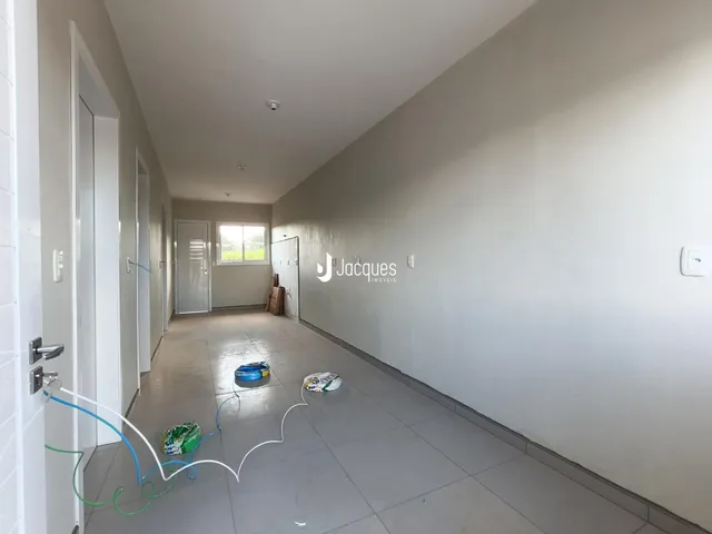 Corredor interno de uma residência com piso de cerâmica.