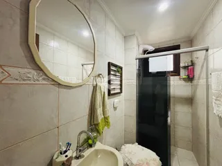 Foto de um banheiro interno com azulejos claros e espelho.