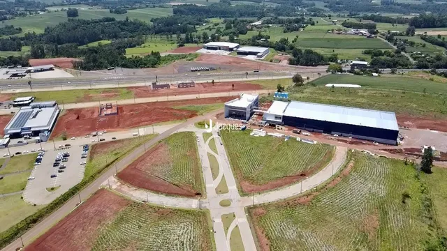 Vista aérea de uma propriedade com grandes áreas de campo e estruturas industriais.