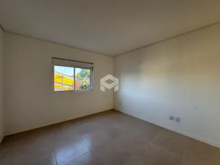 Ambiente interno de uma sala com piso de cerâmica e parede branca.