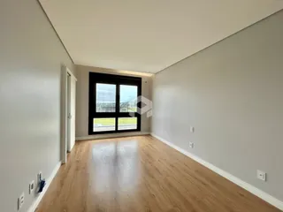 Vista interna de um ambiente com piso de madeira clara e paredes brancas.