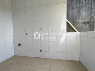 Parede branca com piso claro em um ambiente interno.