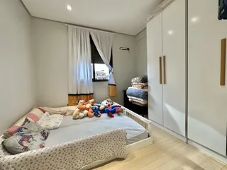 Quarto com cama e armários brancos em um imóvel no Brasil.