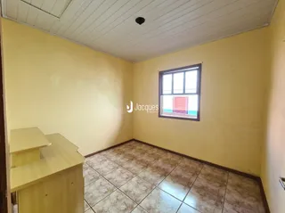 Quarto interno com piso de cerâmica e janela.