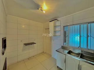 Vista interna de uma cozinha com revestimento de cerâmica branca.