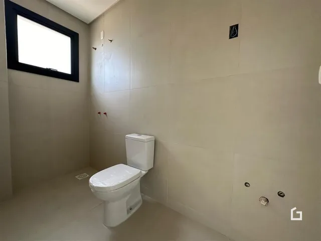 Foto de um banheiro interno com paredes claras e um vaso sanitário branco.