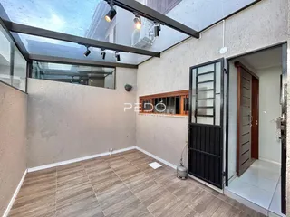 Sala de estar com teto de vidro e paredes claras.