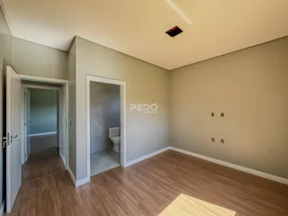 Vista interna de um corredor com acesso a um banheiro em um imóvel no Brasil.