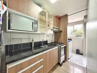 Cozinha moderna com armários de madeira e bancada escura.