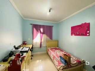Quarto com cama e janela decorada em uma residência.