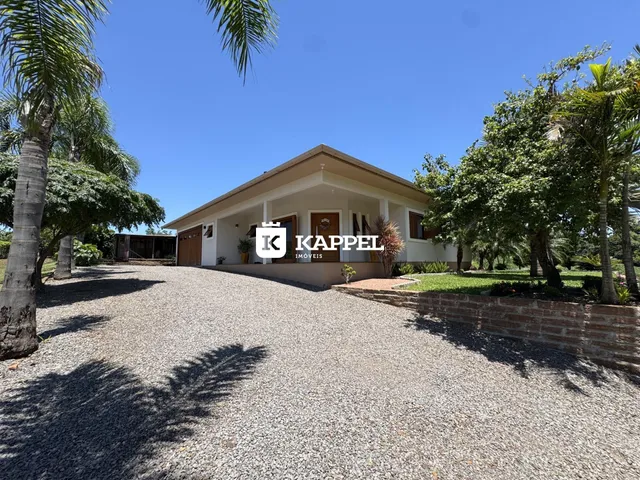 Fachada de uma casa em Lajeado, Brasil, com paisagismo e acesso por estrada de cascalho.