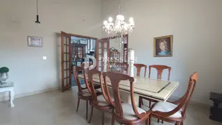 Uma sala de jantar com mesa de madeira e cadeiras em um ambiente claro.