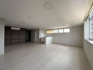 Ambiente interno amplo com piso de cerâmica e painel de madeira.